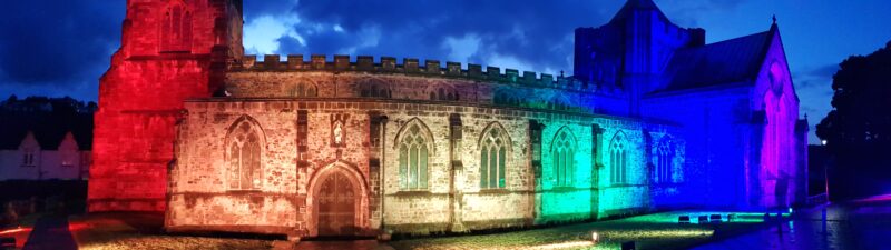 Bangor Cathedral lit in Pride Colours at North Wales Pride after the Pride Parade