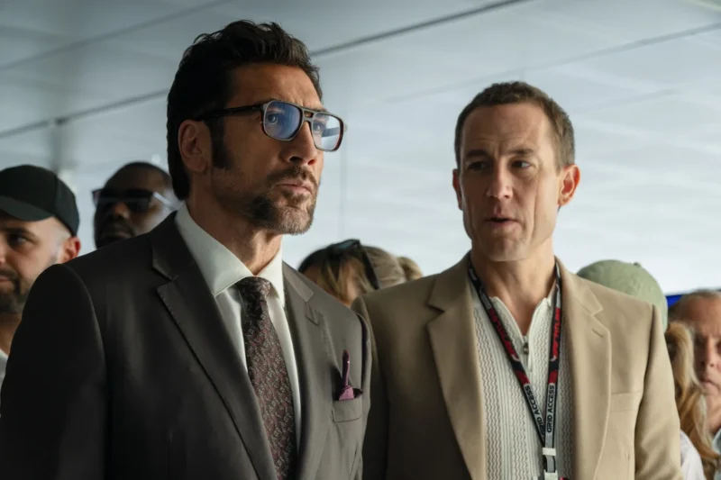 (L-r) JAVIER BARDEM as Ruben Cervantes and TOBIAS MENZIES as Peter Banning in Apple Original Films’ F1® The Movie, a Warner Bros. Pictures release. (PRESS KIT)